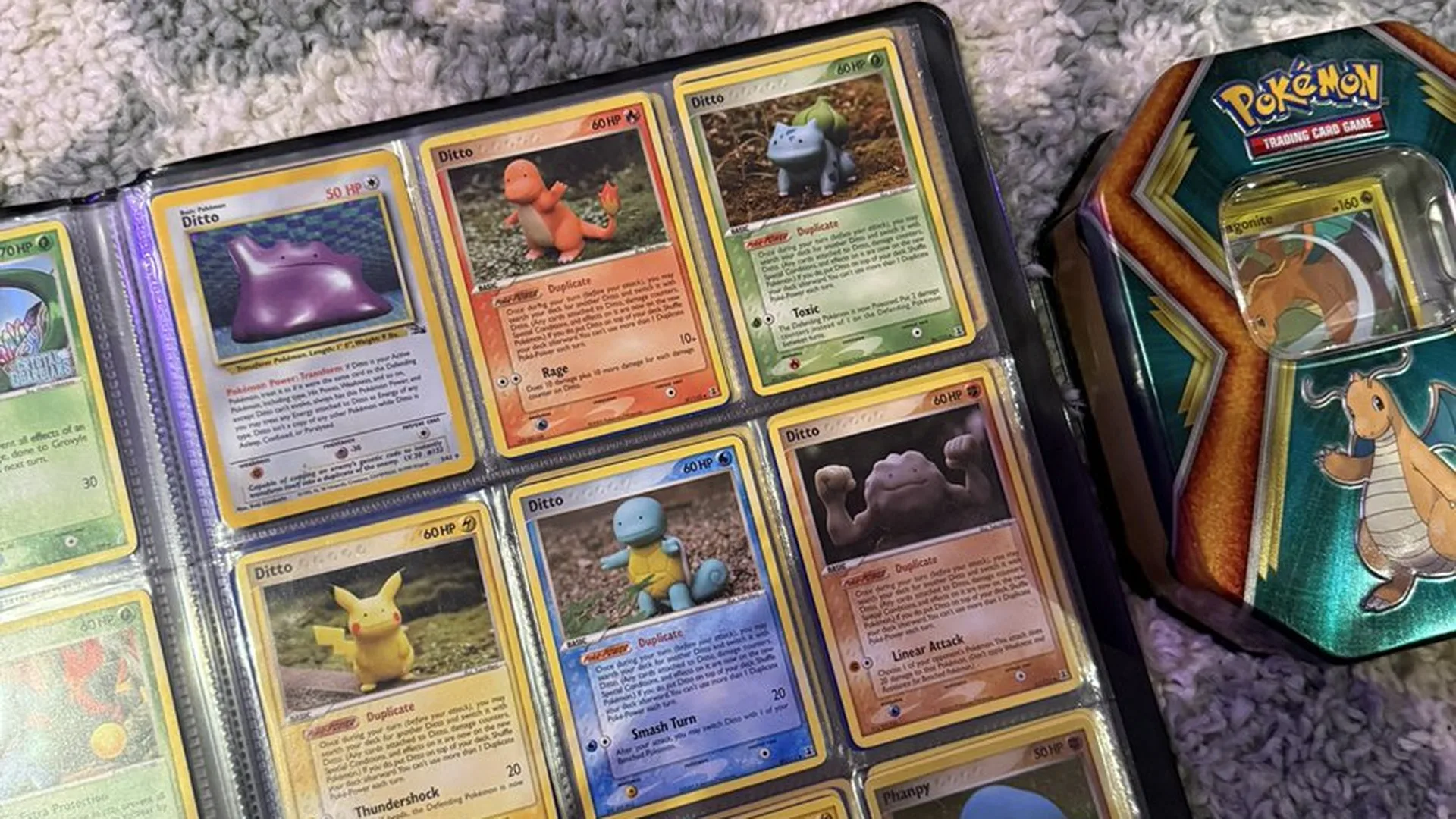 AB BAE's binder page of Ditto cards next to a Pokémon TCG tin